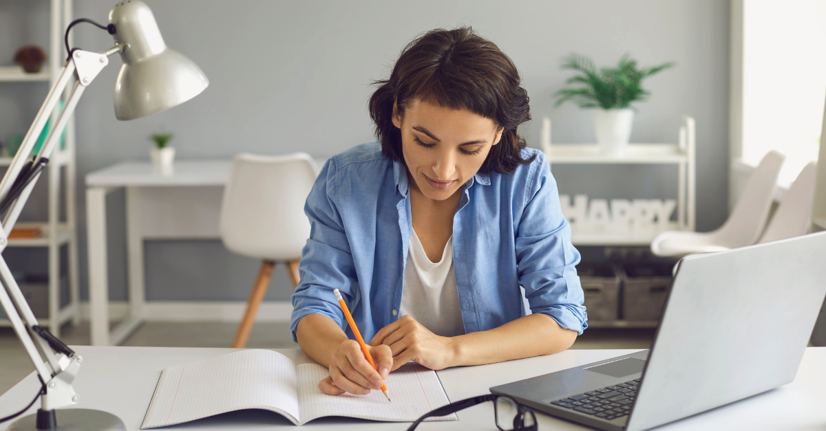 Woman taking notes during online training session